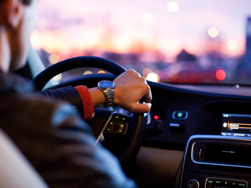 View from behind the steering wheel of a car at dusk